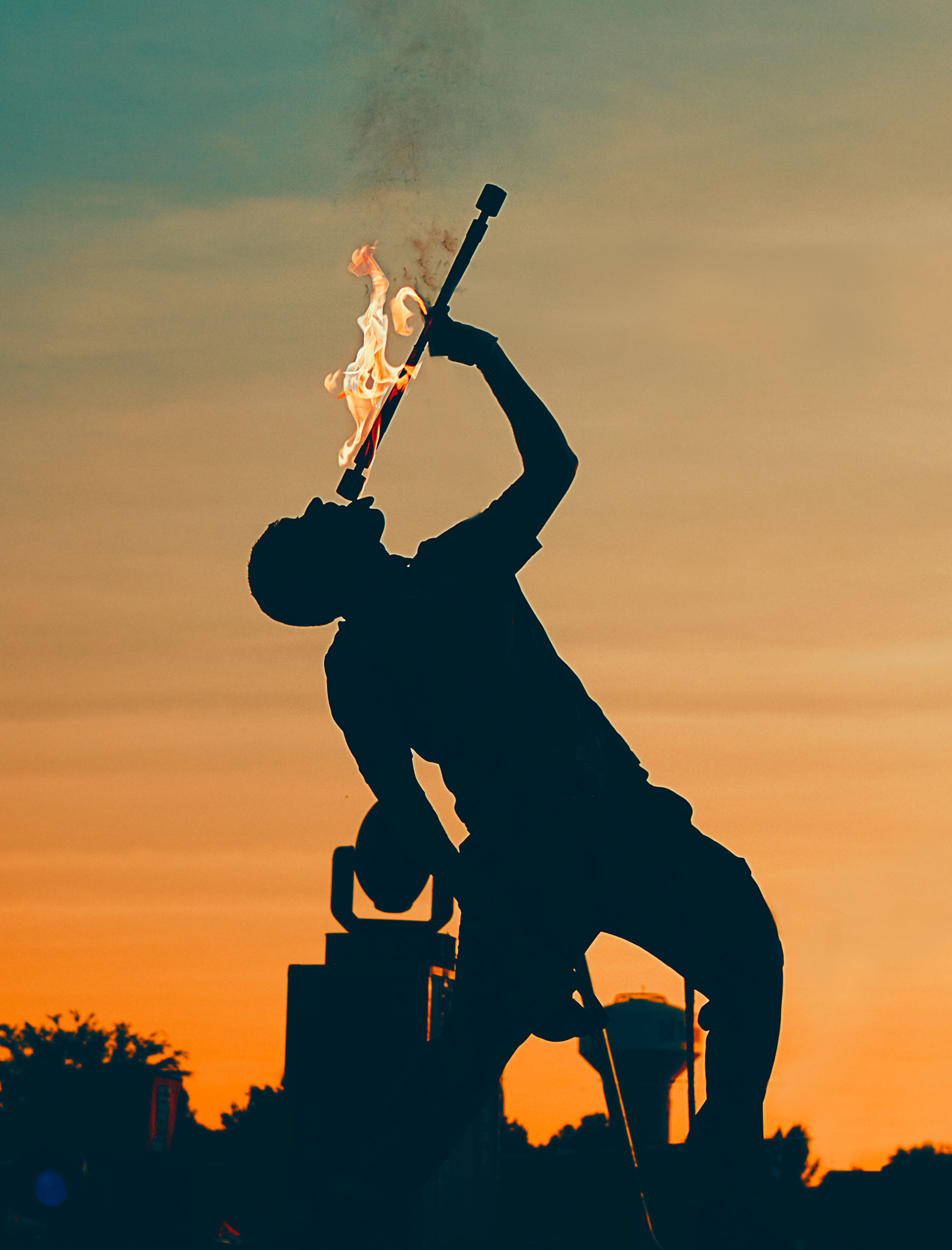 FireGuy eating fire during a sunset.