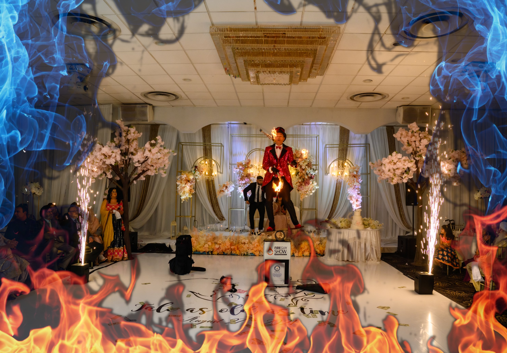 FireGuy juggling while standing on a plank, on a pipe, on a box at a wedding reception inside a building.