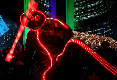 FireGuy looking to be playing with an LED play sword while doing a show on the street at night.